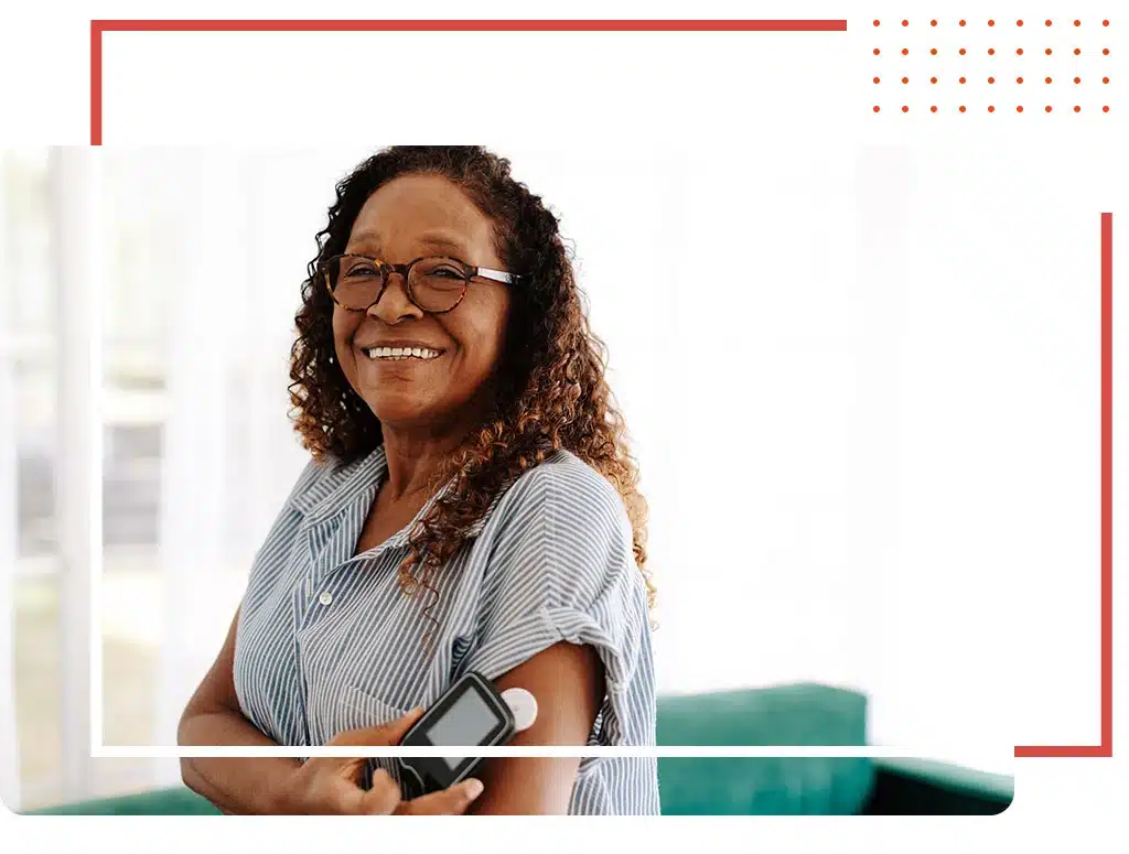 Smiling woman using a glucometer to monitor her health, highlighting compassionate chronic care management services in Katy, TX.