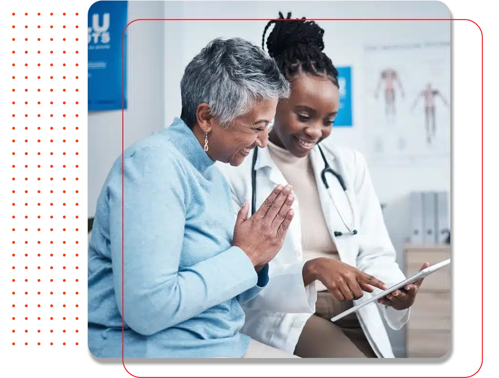 Smiling primary care doctor at Macie Meical providing exceptional healthcare to a senior patient, using a digital tablet during a consultation, emphasizing compassionate and modern medical services.