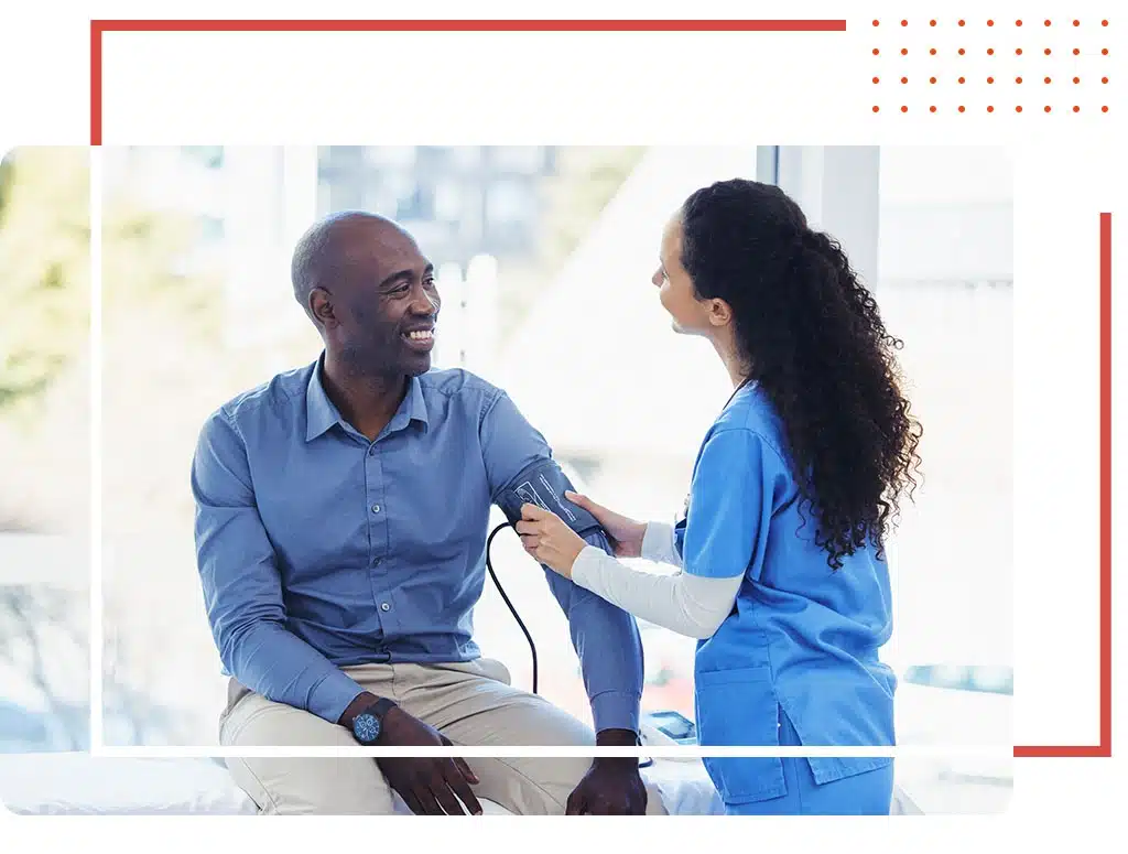 Male patient smiling during a health checkup with a doctor, emphasizing expert men’s health services in Katy, TX.