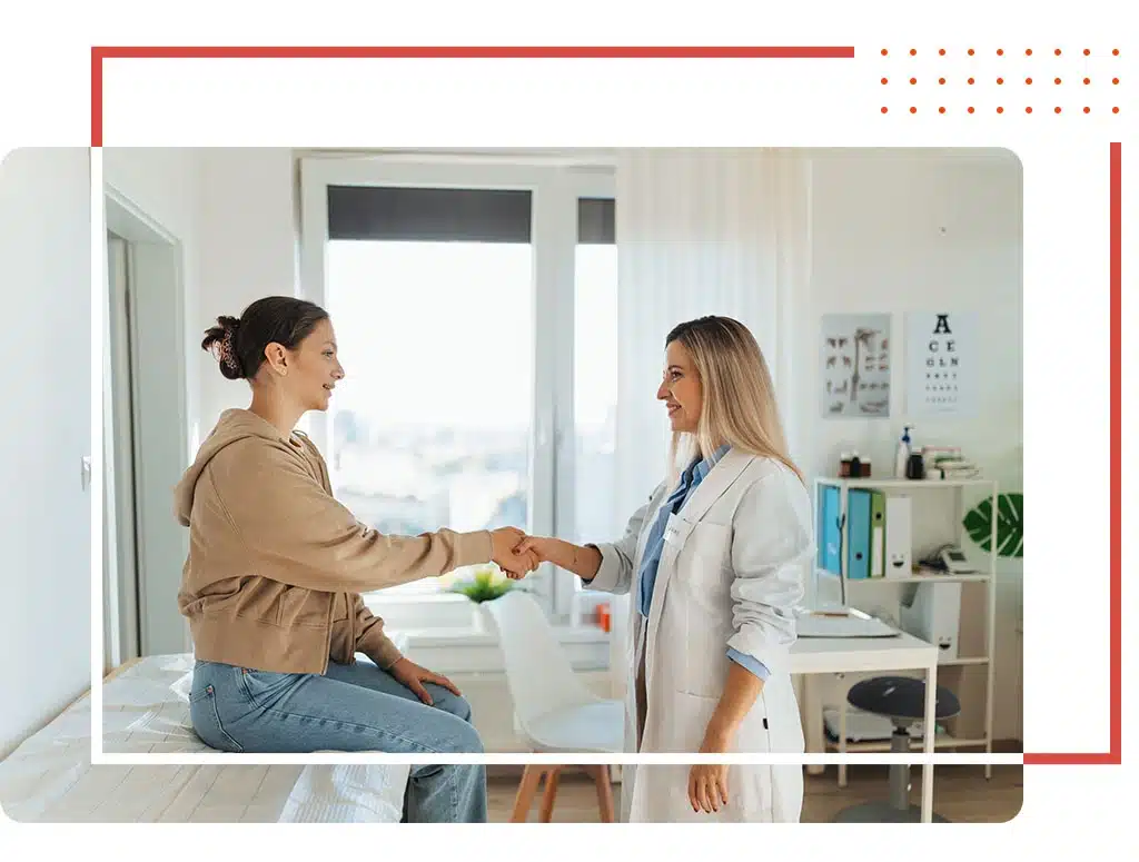 Female primary care physician in Katy, TX, warmly greeting a patient in a modern clinic, symbolizing personalized healthcare and compassionate medical services.