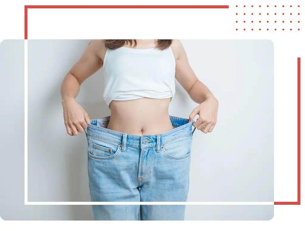 Successful weight loss transformation at a weight loss center in Katy, TX, featuring a woman showing significant progress with loose-fitting jeans.