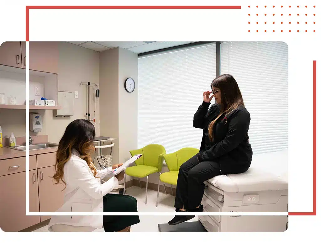 Compassionate women's health doctor in Katy, TX, consulting with a patient in a modern medical clinic, focused on personalized care and wellness.